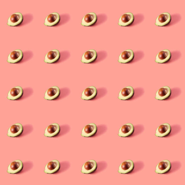 Fresh ripe avocados on a pink background.