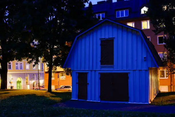 Karlstad, Sweden A small house in the church yard juxtaposes with apartment buildings in the background.