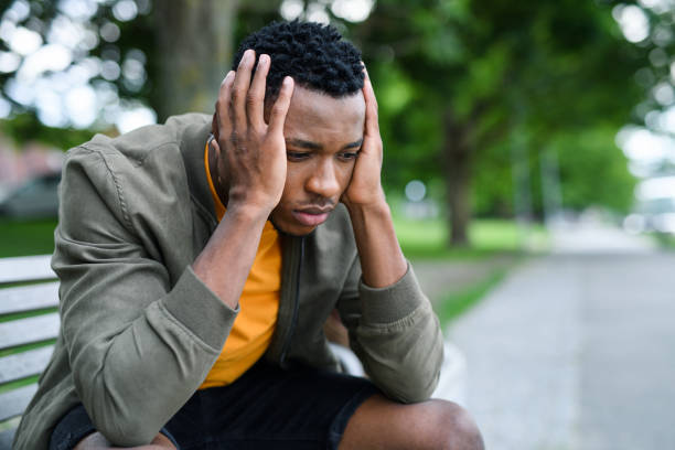 istock Frustrated young black man sitting on bench outdoors in city, protest concept. 1272650820