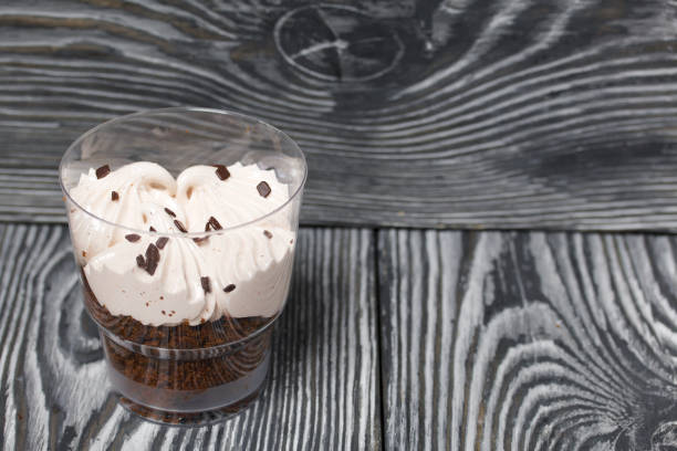 istock Zephyr in a glass. With biscuit and chocolate. On pine boards painted black and white. 1272651470
