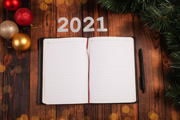 istock An open notebook on the table with Christmas decorations. Targets for 2021, empty space for entries. Plans and challenges for the coming year, desires and dreams. 1272653464