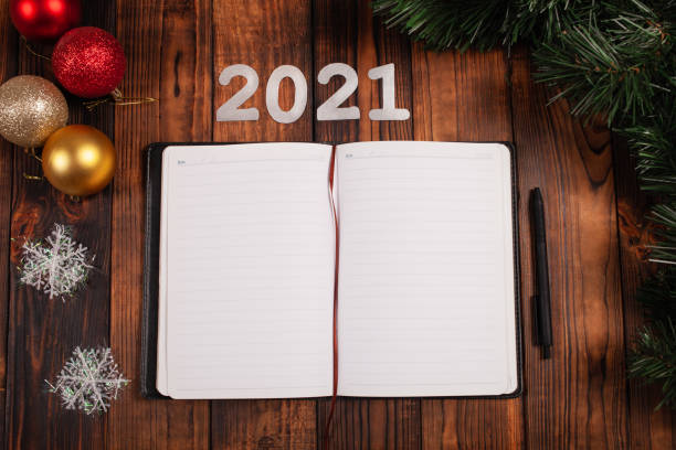 istock An open notebook on the table with Christmas decorations. Targets for 2021, empty space for entries. Plans and challenges for the coming year, desires and dreams. 1272653486