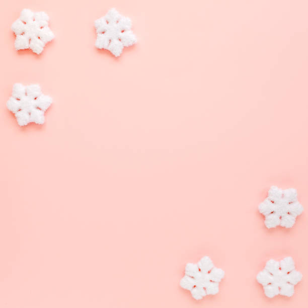 istock Christmas frame with white christmas snowflakes on pink background. Christmas composition, wallpaper. Flat lay, top view 1272664005