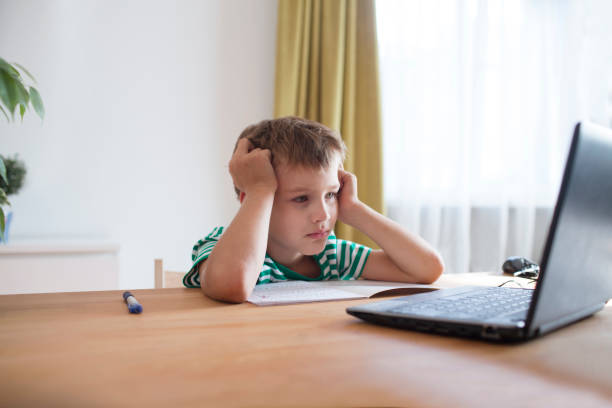 istock Preteen schoolboy  is using a laptop and study online at home. homeschooling, distant learning 1272664573