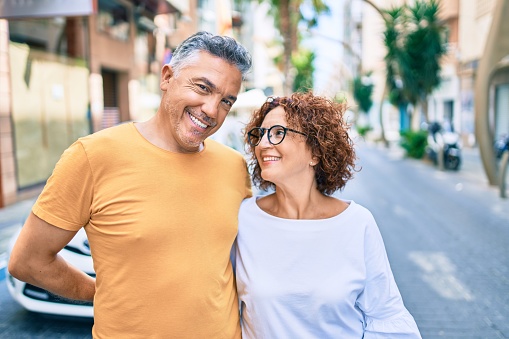 Middle age couple smiling happy standing at street of city.