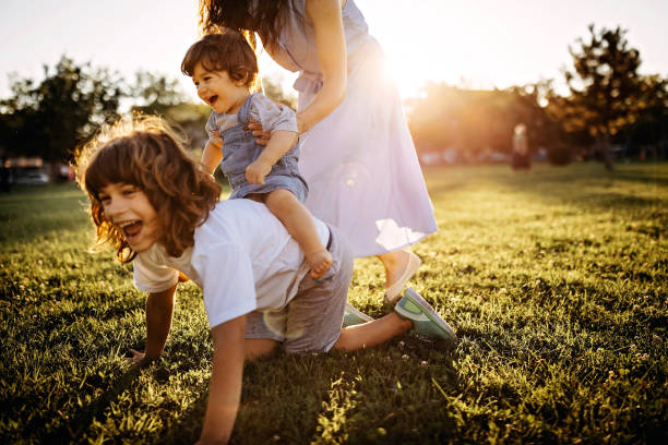 istock Mother playing with kids in meadow 1272665780