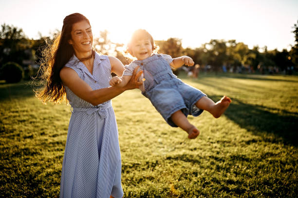 istock Mother playing with her baby in meadow 1272666266