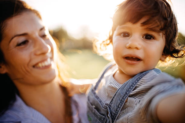 istock Mother playing with her baby in meadow 1272666292