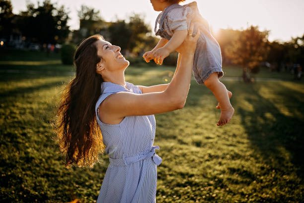 istock Mother playing with her baby in meadow 1272667171