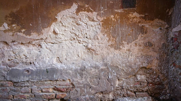 istock The Old Brick Wall Was Ragged Off And Destroyed. Under Several Layers Of Concrete Plaster There Are Rows Of Bricks. 1272667604
