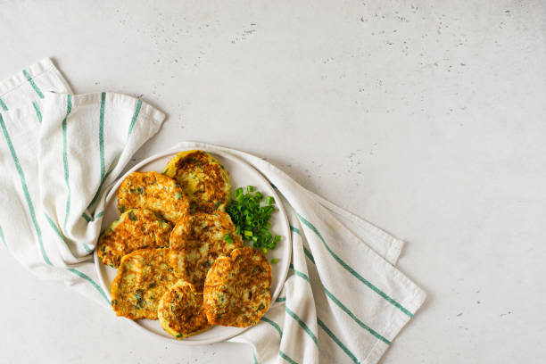 istock Zucchini pancakes with onion and parsley on white background 1272667767