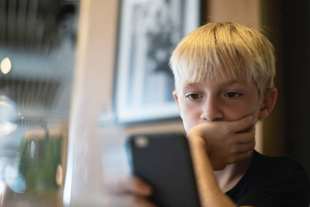 istock Bored kid with smartphone, child addicted to smartphone concept. 1272669835