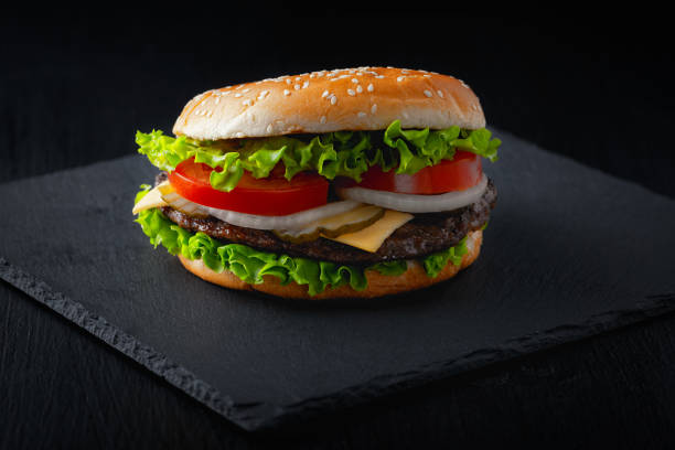 istock fresh delicious burger on black background 1272672327