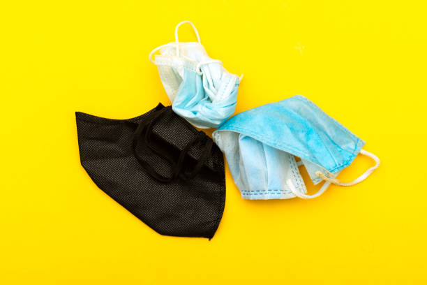 istock used medical  and textile mask on yellow background 1272673777