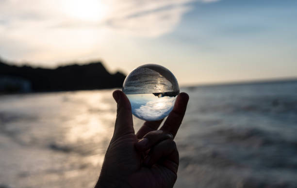 istock man's hand with crystal ball sunset sea 1272673878