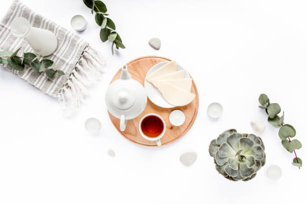 istock Breakfast with cheese, leaves eucalyptus, cutting board and black tea composition with on white background. Flat lay, top view 1272679449