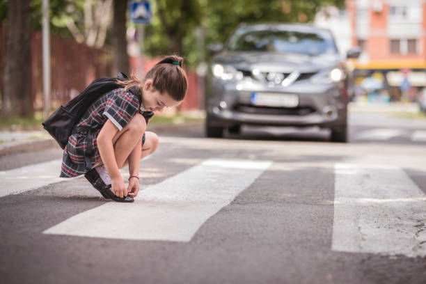 chica arreglando su zapato en el paso de peatones - crossing zebra crossing crosswalk street fotografías e imágenes de stock