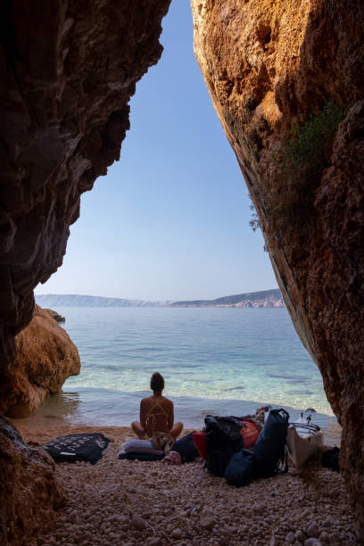 istock Woman sitting on hidden beach among the cliffs 1272681570