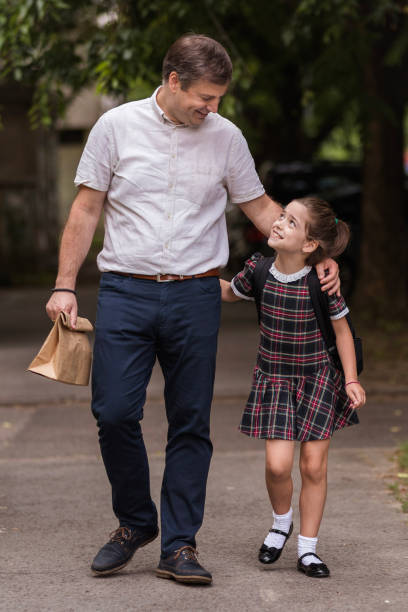 istock Man and his daughter walking to school hugging 1272681583