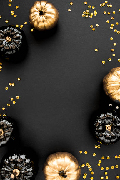 istock Modern background with black and gold Halloween pumpkin with copy space for text. isolated on black background. Flat lay, top view 1272682628