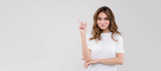 istock Business woman points finger presenting the product, isolated on white background. Empty space, banner size 1272683798