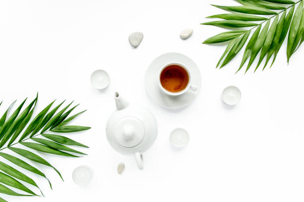 istock teapot, tea mug and palm leaf branches, flat lay, top view 1272687741