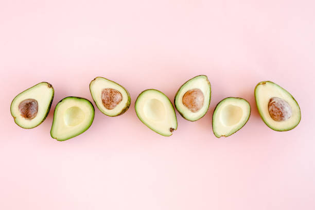 istock Avocado on pink background. Tropical abstract background with avocado. Food concept. flat lay, top view 1272689708