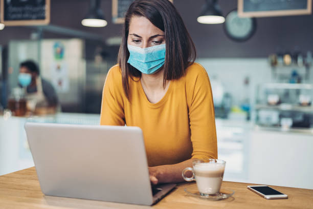 istock Worried woman wearing a mask and using laptop 1272690626