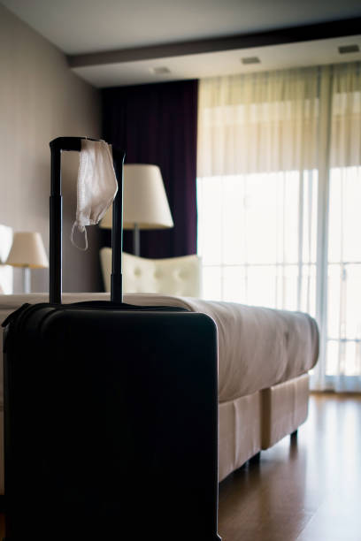 istock Face Mask and Suitcase in the Hotel Room 1272695258