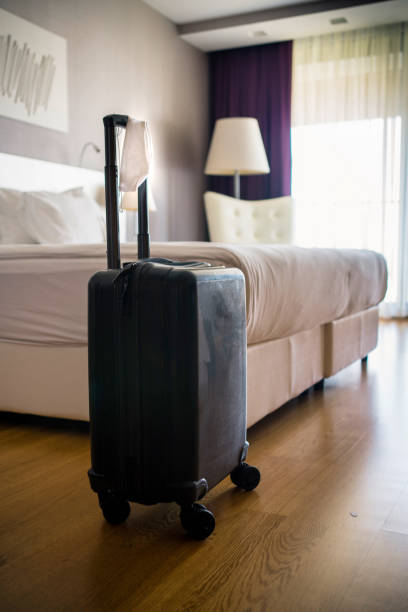 istock Face Mask and Suitcase in the Hotel Room 1272695299