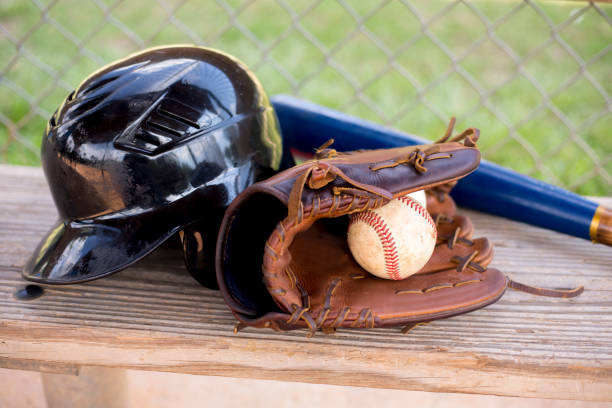 野球の季節はここにあります。 ダッグアウトベンチのバット、手袋、ヘルメット、ボール。 - dugout baseball bench bat ストックフォトと画像