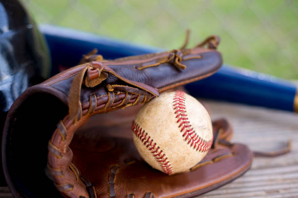 野球の季節はここにあります。 ダッグアウトベンチのバット、手袋、ヘルメット、ボール。 - dugout baseball bench bat ストックフォトと画像