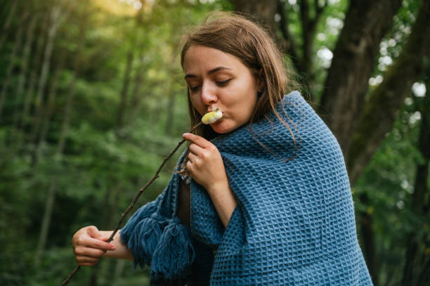 istock Young woman eating roasted marshmallows 1272702993