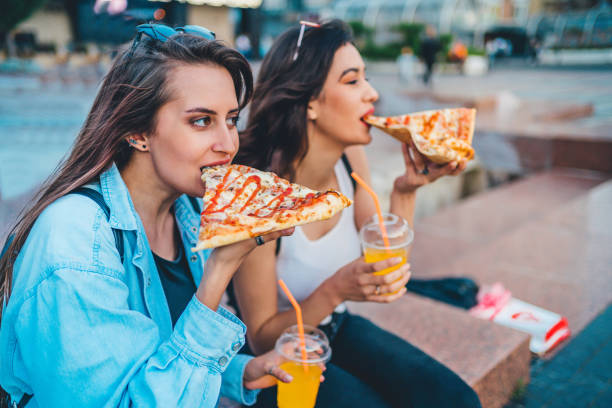 istock Girls eating pizza and have fun 1272705940