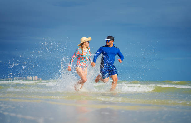 istock Young hispanic couple running on a Florida beach 1272709332