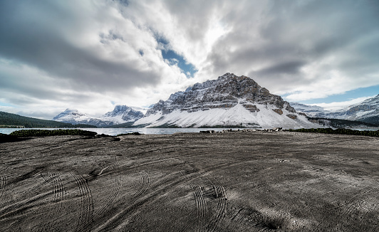 empty dirt beach with traces against Canadian Rockies