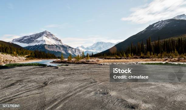 Empty Dirt Beach With Traces Against Canadian Rockies Stock Photo - Download Image Now