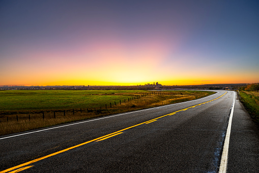 empty highway with calgary skyline background in sunset.