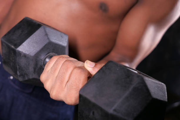 istock young man hand exercising with dumbbells indoor. 1272714222