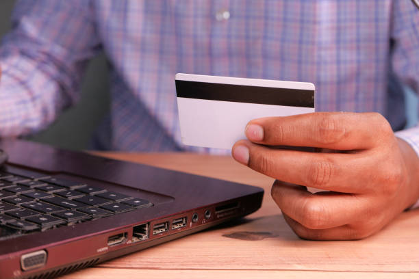 istock man hands holding credit card and using laptop shopping online 1272714921