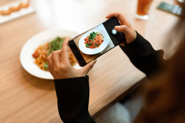 Taking a picture of pasta with smartphone. Taking a picture of pasta with smartphone. chinese ethnicity china restaurant eating stock pictures, royalty-free photos & images