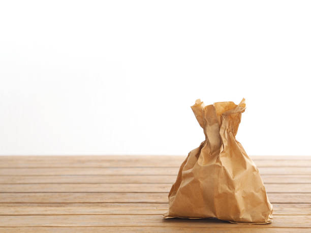 istock recycle paper bag on wooden table 1272718804