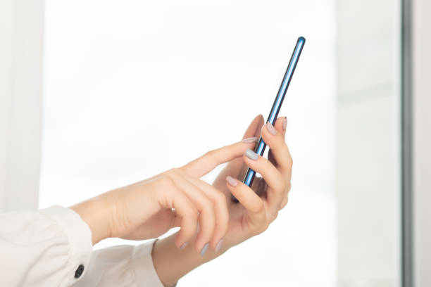 istock female hands with a phone at a table typing text on the screen 1272721991