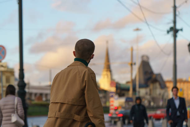Moscow, Russia - September10,2020: Moscow cityscape at autumn sunset after the rain. Concept of big city lifestyle. Coronavirus pandemic time. Middle aged man admires the city. Photography with defocused background.