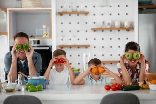 istock Mother and father making breakfast with sons 1272736908