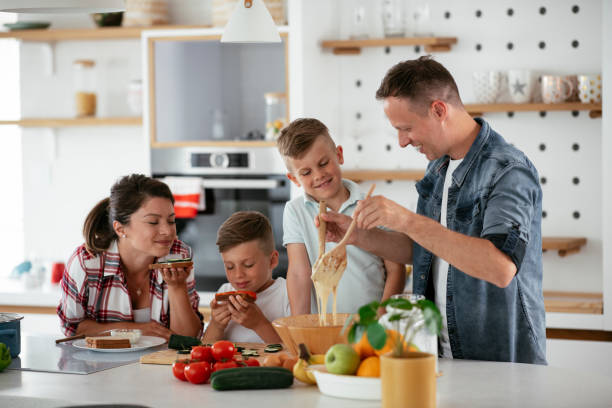 istock Mother and father making breakfast with sons 1272737476