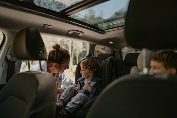 Getting ready for a road trip Photo of two boys, brothers, getting ready for a car road trip with their mom family in car stock pictures, royalty-free photos & images
