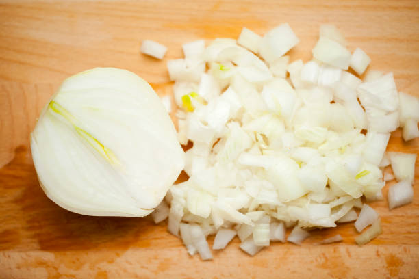 istock Half onion and chopped onion on wooden cutting board. 1272740330