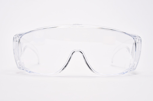 Protective transparent plastic eyewear glasses on white background