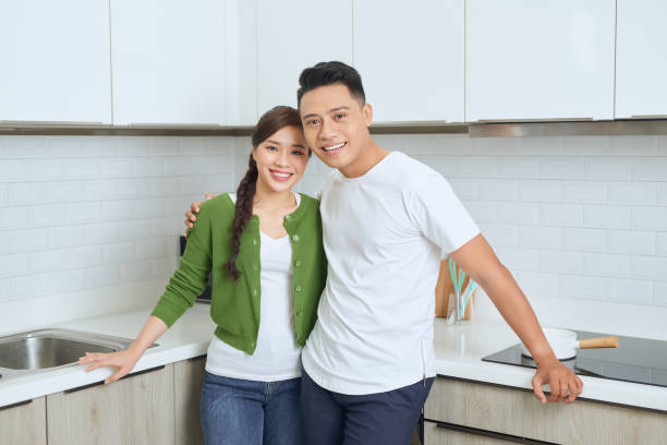 istock Attractive young woman and handsome man are enjoying spending time together while standing on light modern kitchen. 1272740513